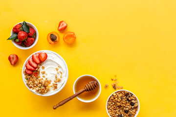 Healthy breakfast flat lay. Yogurt with muesli and strawberry in bowl. Top view