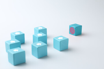 Obraz premium Targeting. Light blue cubes with arrows pointing at one with bullseye on white background