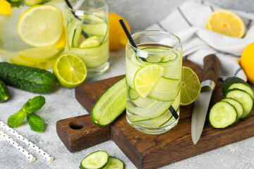 Cucumber water with lemon, lime and mint on a wooden table. Water infused with sliced...