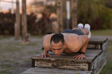 Young man in push up position at outdoor gym