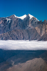 High rocky mountains with the glaciers above the clouds. Himalaya, Nepal.