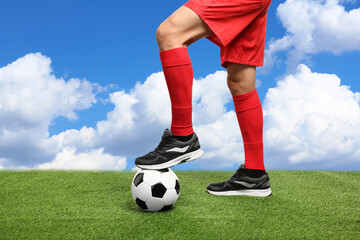 Football player with soccer ball under blue sky, closeup
