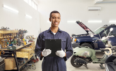 African american car mechanic holding a clipboard at a garage