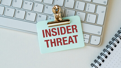 A clip holding a sign that says Insider Threat on a keyboard