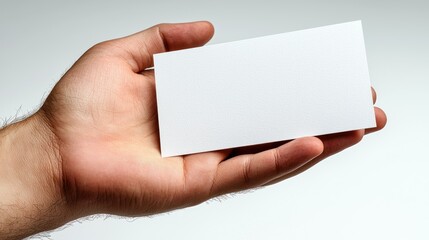 Obraz premium Hand holding a blank white rectangular card