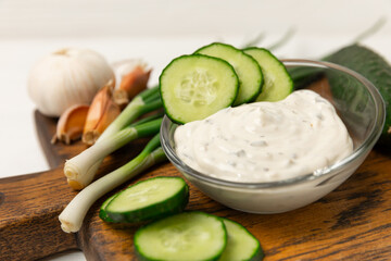 Cucumber sour cream tzatziki sauce on a wooden table.Tartar sauce. Traditional delicious appetizer. yogurt sauce. Tzatziki with ingredients cucumber, garlic,dill,lemon,mint. salad dressing.Copy space