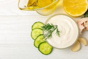 Cucumber sour cream tzatziki sauce on a wooden table.Tartar sauce. Traditional delicious appetizer. yogurt sauce. Tzatziki with ingredients cucumber, garlic,dill,lemon,mint. salad dressing.Copy space