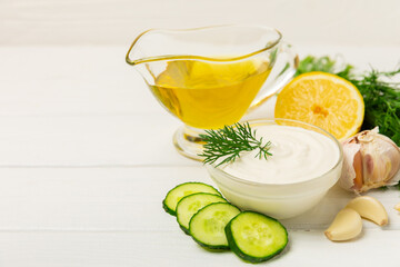 Cucumber sour cream tzatziki sauce on a wooden table.Tartar sauce. Traditional delicious appetizer. yogurt sauce. Tzatziki with ingredients cucumber, garlic,dill,lemon,mint. salad dressing.Copy space