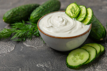 Cucumber sour cream tzatziki sauce on a wooden table.Tartar sauce. Traditional delicious appetizer. yogurt sauce. Tzatziki with ingredients cucumber, garlic,dill,lemon,mint. salad dressing.Copy space