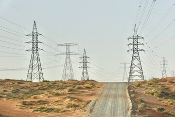 roads in the Dubai desert and high voltage towers with wires

