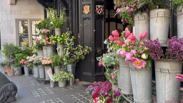 London, UK &ndash; May 10, 2025. Entrance to Liberty store from the flower shop side. A variety of flowers in bouquets on display: roses, snapdragons, anthuriums, lilacs, tansy, anemones, eucalyptus.