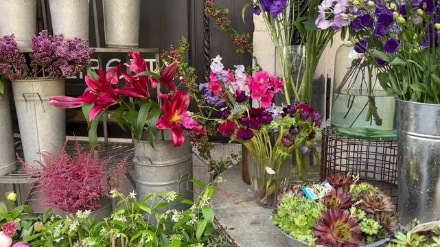 London, UK - 5 May 2025, Red lilies, anemones, and eucalyptus arranged in a bouquet adorn the entrance of Liberty.