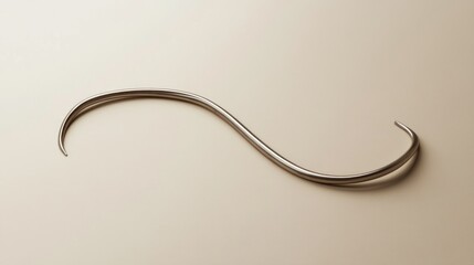 Elegant, metallic, curved line on a light beige surface