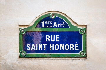 Obraz premium Rue Saint Honore street sign, 1st arrondissement, blue and green plaque on beige wall