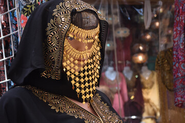 woven ladies handbag with ornament hanging on display at Dubai market

