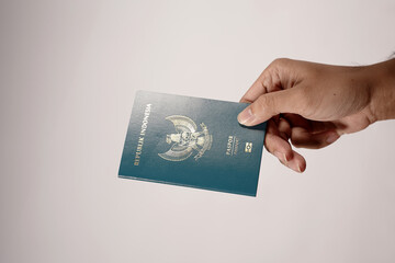 Indonesian passport held in hand isolated on white background