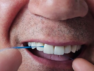 Close look at dental hygiene practice while using floss to clean teeth for better oral health concept