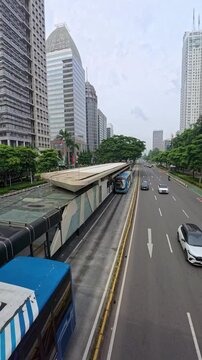 Jakarta, Indonesia - April 21, 2025: TransJakarta stops at a bus stop to pick up and drop off passengers. TransJakarta or Busway is a bus rapid transit (BRT) system in Jakarta, Indonesia.