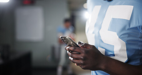 Football, phone and hands of man in locker room for rookie drafting, pro league research and...