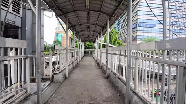 Jakarta, Indonesia - 10 April 2025: Jembatan penyeberangan orang yang menghubungkan ke halte bus TransJakarta