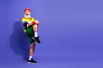 Elderly man in retro sports outfit enthusiastically performing a warmup exercise
