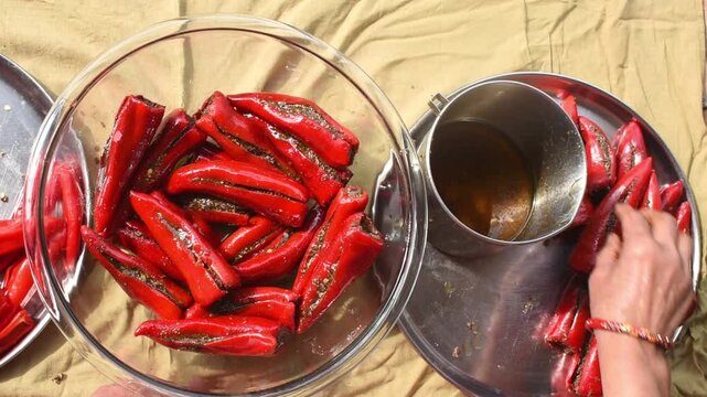 Indian Woman Preparing Red Chilli Pickle at Home &ndash; Traditional Cooking Process . concept of traditional recipes, Indian food preparation, spice culture, and regional cooking methods.