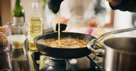 Cooking, pan and recipe with person in kitchen of restaurant closeup with sauce, health or nutrition. Food, gas stove and ingredients with chef in hotel for gourmet cuisine, hospitality or service