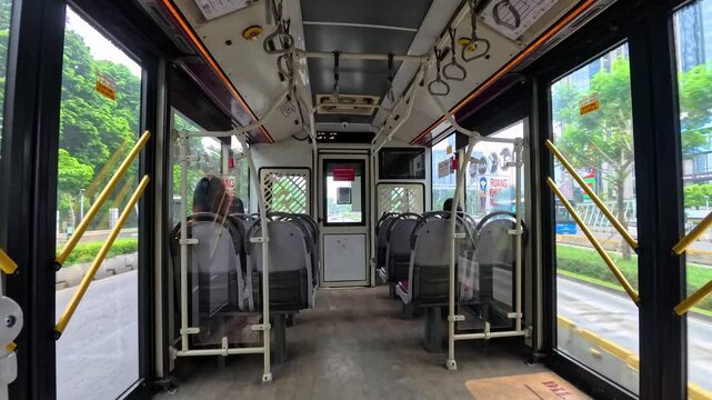 Jakarta - April 3, 2025: Transjakarta bus is empty of passengers. Several passengers are seen filling the seats inside the bus.