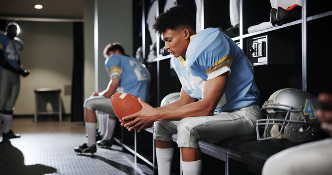Thinking, man and football player with ball in locker room for preparation, sports match and game plan. Athlete, waiting and half time for competition ideas, fitness challenge and tournament choice