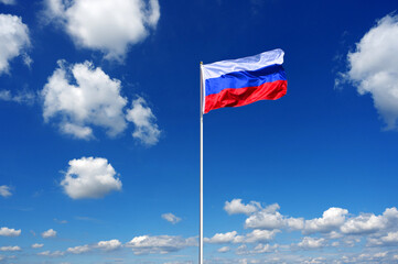 flag of Russia fluttering in the blue sky with cumulus clouds