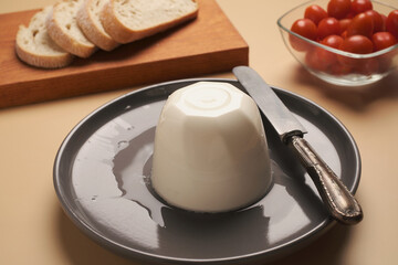 Cheese and bread served with fresh tomatoes on a plate