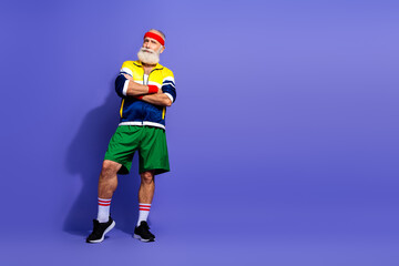 Active man in retro sportswear posing confidently against blue background embracing vintage active lifestyle