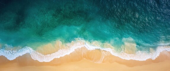 Aerial top view of turquoise ocean water and waves with white foam. Clean sandy tropical beach. Wallpaper