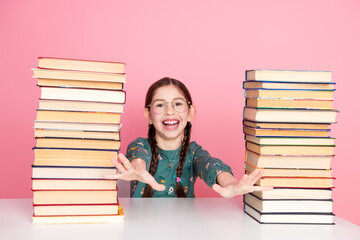 Happy young girl embracing joy with book in stack, in a vibrant setting, conveying education and fun in daily life