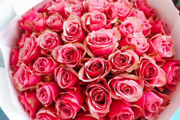 Beautiful bouquet of pink roses arranged elegantly in a decorative white wrapper