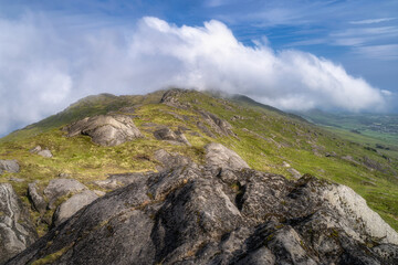 This stunning view features a majestic Slieve Foye mountain peak surrounded by lush greenery and fluffy clouds, perfect for nature enthusiasts and landscape lovers, Carlingford, Ireland