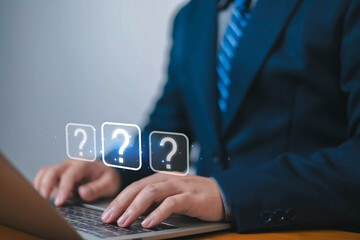Question mark, Businessman showing question mark icon in front of laptop, Technology question concept, FAQ, Wondering questioning and problem-solving, Q and A, ask	