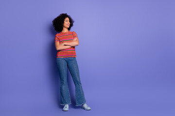 Young woman posing against vibrant purple background with casual outfit and confident look,...