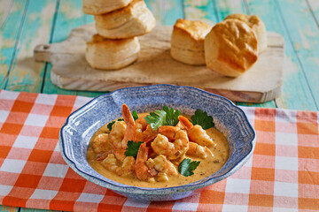 shrimp creole seafood bisque with biscuits on a gingham napkin