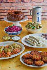 October fest food consisting of potato pancake, stuffed cabbage, bratwurst, sauerkraut, red...