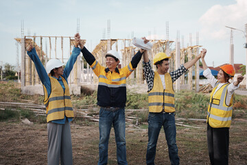 A team of engineers wearing hard hats inspect construction and inspect the site to ensure quality...