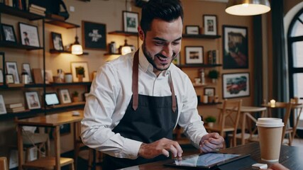 Smiling barista using digital tablet at cafe counter - Powered by Adobe