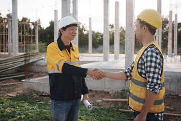 A team of engineers wearing hard hats inspect construction and inspect the site to ensure quality...