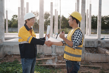 A team of engineers wearing hard hats inspect construction and inspect the site to ensure quality...