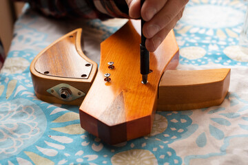 The guitar master screw the slide guitar parts together