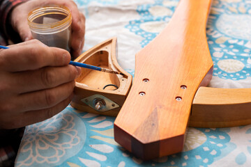 The guitar master paints the outline of the slide guitar's tone block body