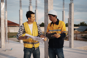 A team of engineers wearing hard hats inspect construction and inspect the site to ensure quality...