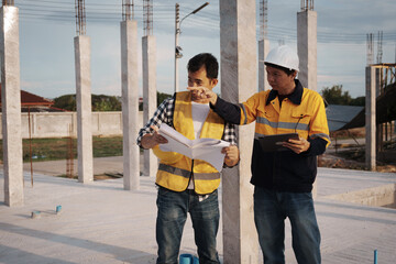 A team of engineers wearing hard hats inspect construction and inspect the site to ensure quality...