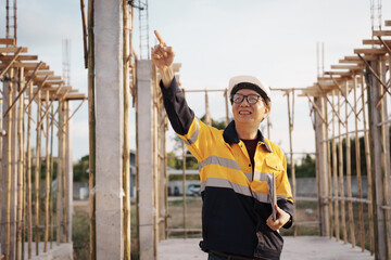 A team of engineers wearing hard hats inspect construction and inspect the site to ensure quality...