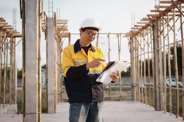 A team of engineers wearing hard hats inspect construction and inspect the site to ensure quality...